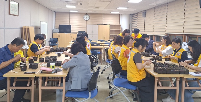 3-2 커피박으로 제작한 틀(컨테이너)에 레인보우 칼라끈을 정성스럽게 묶고 있다.jpg
