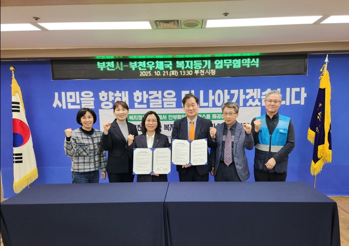 2-3. 정애경 부천시 복지국장, 김호 부천우체국장, 협약식 관계자들이 단체 사진을 찍고 있다.jpg