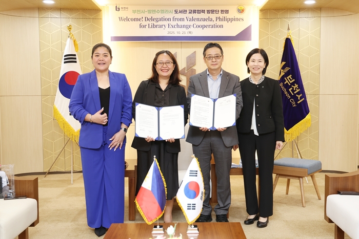 1-2. 남동경 부천시 부시장과 필리핀 발렌수엘라시 방문단이 공공도서관 파트너십 양해각서(MOU)를 들고 기념사진을 찍고 있다.JPG