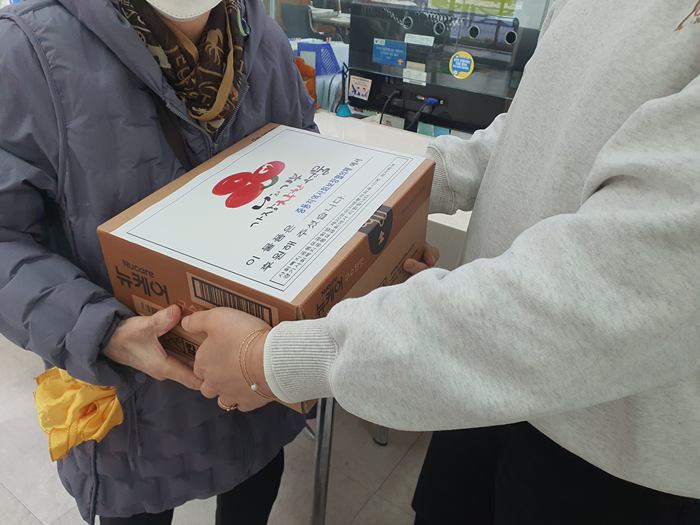 1.2.어르신에게 뉴케어를 전달하고 있다..jpg