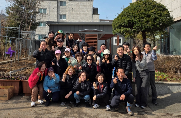 1-2괴안동 통장협의회와 주민 등 참석자들이 봄꽃 식재를 마친 뒤 청사 앞에서 기념촬영을 하고 있다.jpg