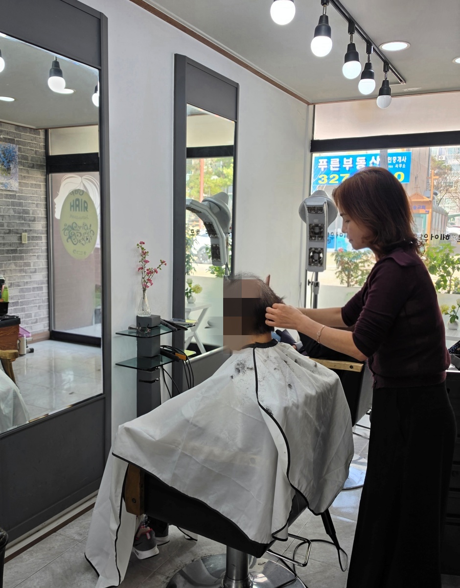 7-2. 프로헤어월드 원장이 저소득 어르신에게 재능기부 미용 봉사를 하고 있다..jpg