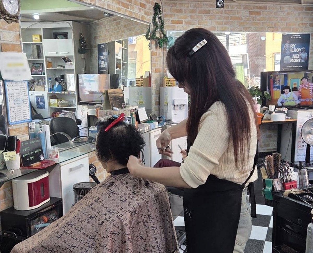 2.1. 어르신 머리를 손질해드리는 마을지니어스 활동 모습.jpg