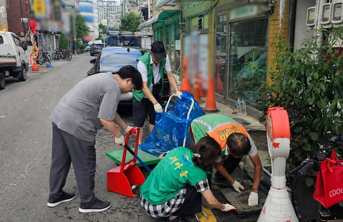 2.1. 원미2동 자율방재단원들이 도로변 빗물받이를 정비 중이다.jpg