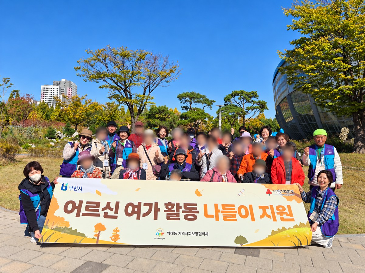4-1. 약대동 지역사회보장협의체 위원들과 어르신들이 상동호수공원 수피아 앞에서 기념촬영을 하고 있다.jpg